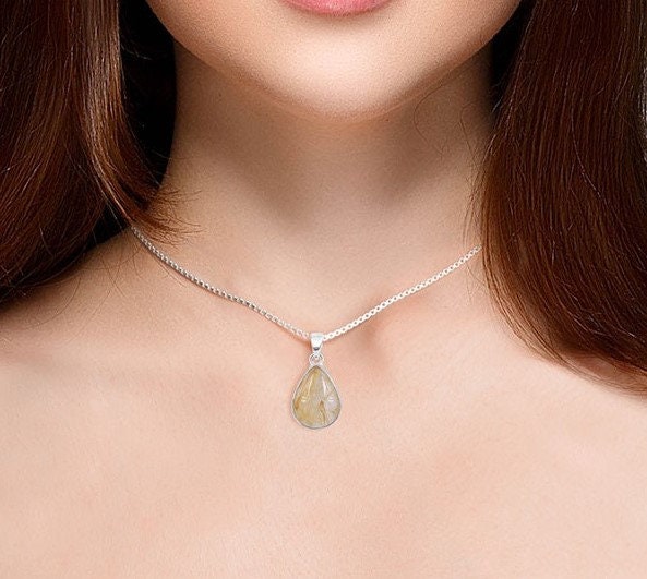 Necklace with a teardrop-shaped pendant worn by a person