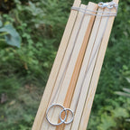 Silver necklaces on a wooden stick with a natural background