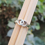 Silver ring on a wooden stick with a blurred natural background