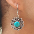 Silver earring with turquoise stone worn on an ear