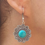 Silver earring with turquoise stone worn on an ear