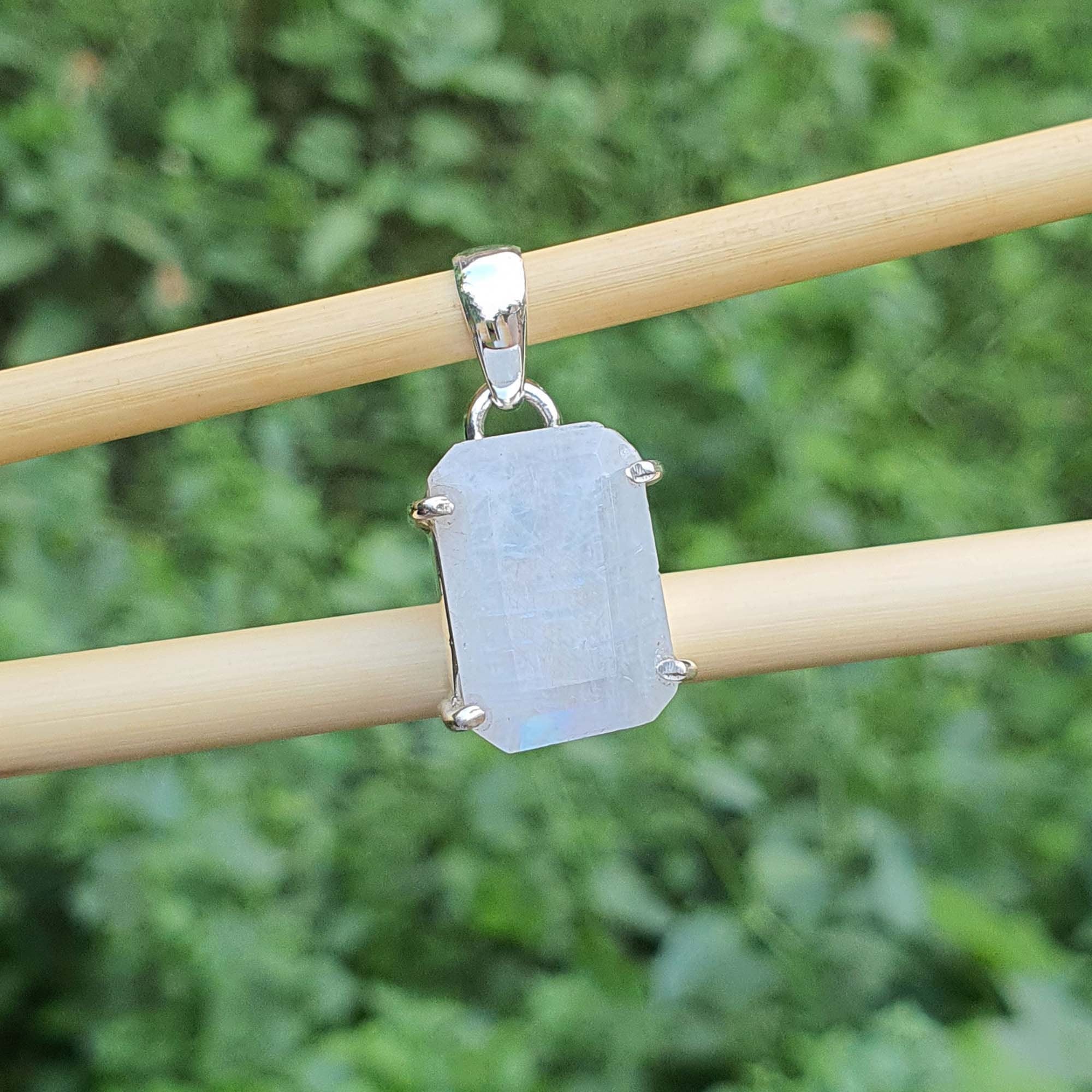 Crystal pendant on a wooden stick with a blurred green background