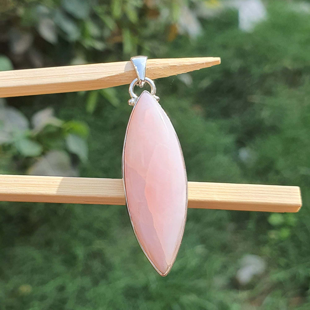 Pink pendant on a stick with a blurred green background