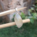 Teardrop-shaped pendant on a stick with a blurred natural background